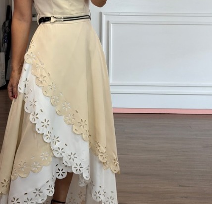 Detalle del ruedo de encaje y el cinturón del vestido crema